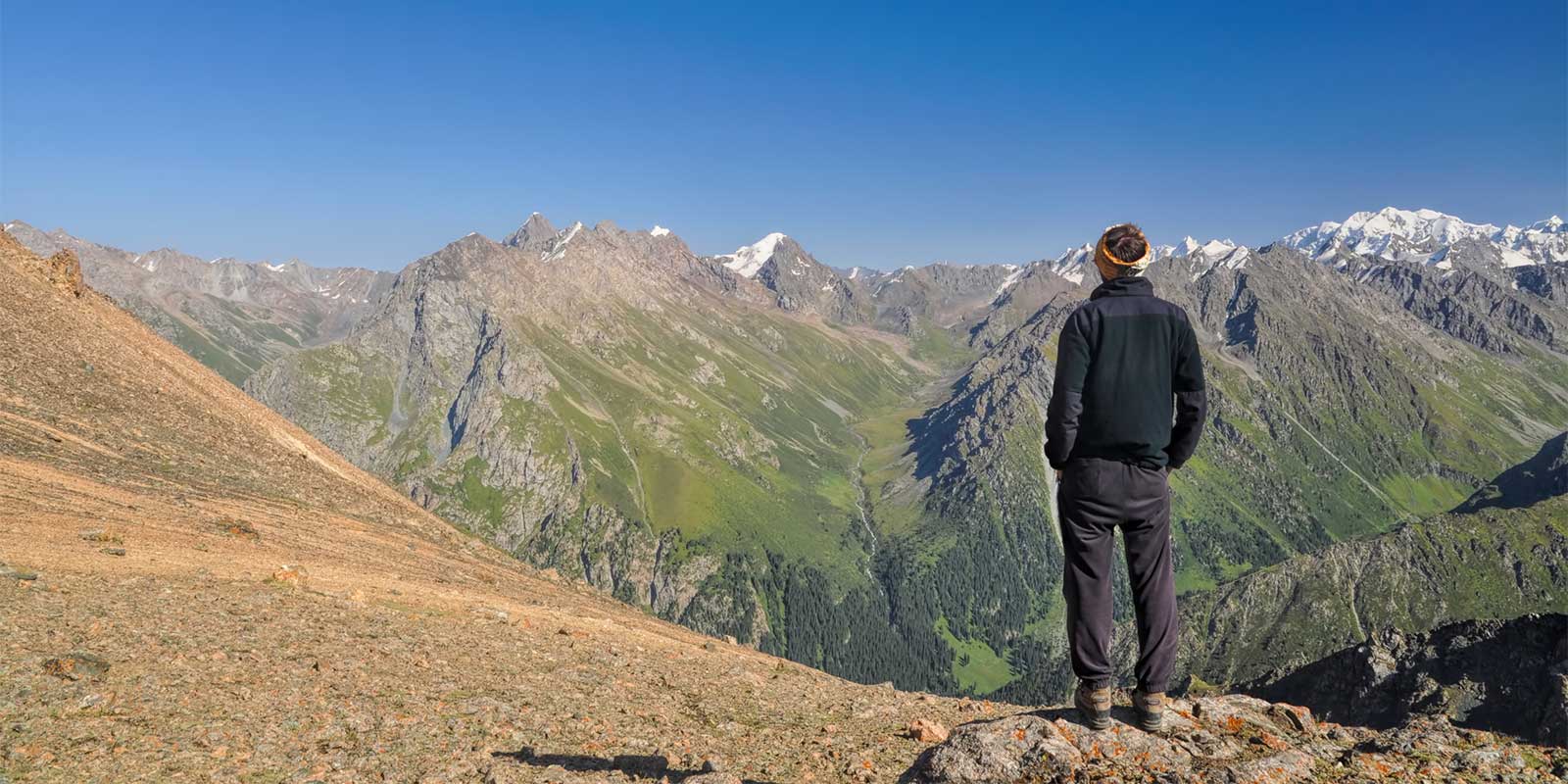 Trekker admiring the view in Tien Shan Mountains, Kyrgyzstan
