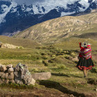 A woman walking with a child on her back in Peru. 