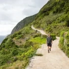 Hiker walking along the coast of Sao Jorge in the Azores