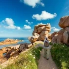 Hiker walking along the Pink Granite Coast, Brittany, France