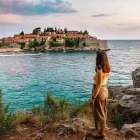 Woman looking at the fortified island Sveti Stefan, Montenegro.