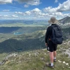 Hiker admiring the views from the Crvena Greda loop down to the Black Lake in Durmitor National Park, Montenegro.