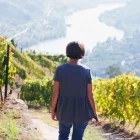 Woman admiring the view of the Douro Valley from a vineyard in Portugal