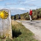 Hiker passing sign of Camino de Santiago