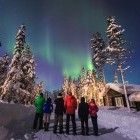 Group of hikers enjoying the Northern Lights in Lapland, Finland