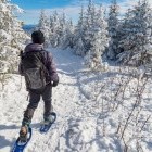 Hiker snowshoeing in the snowy winter landscape
