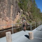Hiker looking at Värikallio rock painting in Finland
