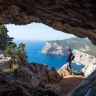 Hiker looking at seaview from cave in Sardinia