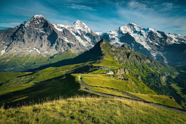 Grassy mountains with snowy mountains in background
