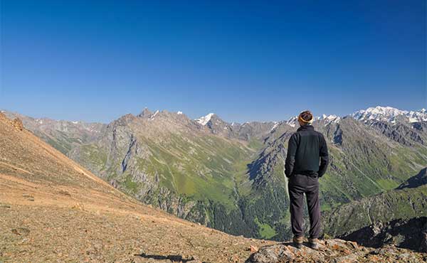 Trekker admiring the view in Tien Shan Mountains, Kyrgyzstan